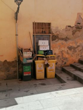 Rio Marina: bidoni di rifiuti traboccanti bloccano la porta della sagrestia della Chiesa di San Rocco