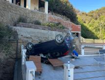 Sfonda il muro che delimita il parcheggio e cade con l'auto nel giardino sottostante